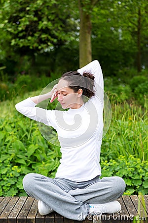 Young attractive woman practising yoga in a park Stock Photo