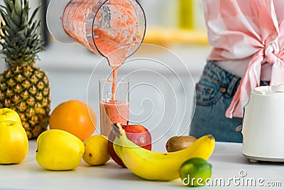 View of young woman pouring delicious smoothie in glass Stock Photo