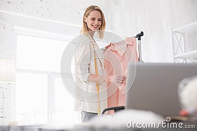 Exuberant female couturier reading feedback Stock Photo