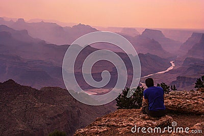 Man sitting looking out over the Southern Rim of the Grand Canyon Editorial Stock Photo