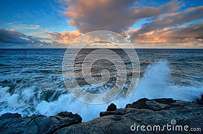 Views of the sea and black lava rocks at sunset Stock Photo