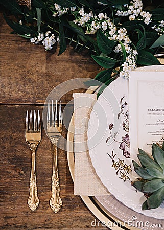 A vignette of a plate setting and gold vintage flatware from a table scape designed for a boho style event with rustic touches Stock Photo