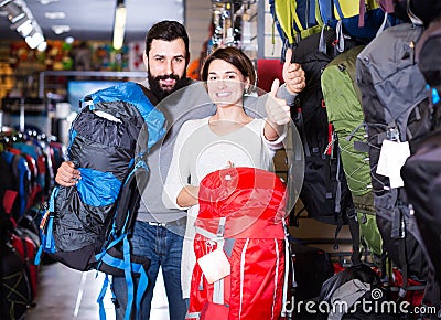 Vigorous couple examining rucksacks in sports equipment store Stock Photo