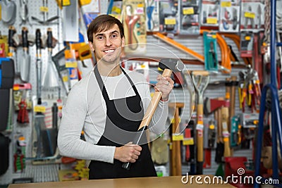 Vigorous young salesman in apron with tools Stock Photo