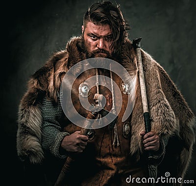 Viking with cold weapon in a traditional warrior clothes Stock Photo