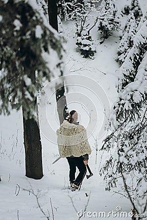 Viking hunter in pelt walking in snow winter forest with steel a Stock Photo