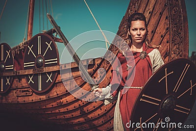 Viking woman in traditional clothes near drakkar Stock Photo