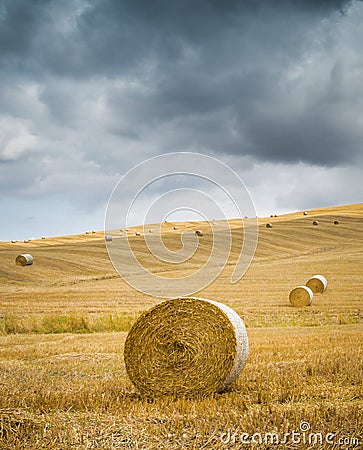 Villa on top of hill overlooks recently harvested hay bales Stock Photo