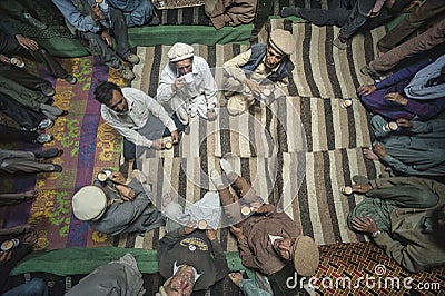 The village elders sit in the center of the house surrounded by the rest of the inhabitants and drink milk tea and bless the house Editorial Stock Photo