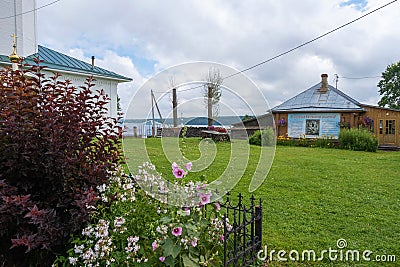 Green grassy lawn in the courtyard of the Holy Cross Church, 07/18/2019, the village of Vozdvizhenie, Ivanovo region, Russia Editorial Stock Photo