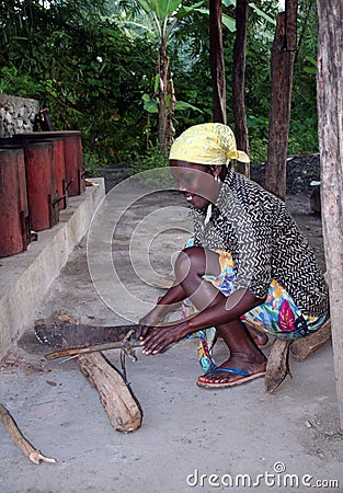 Village woman chopping wood Editorial Stock Photo