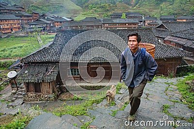 Villager Asian man peasant farmer with a wicker basket on his ba Editorial Stock Photo