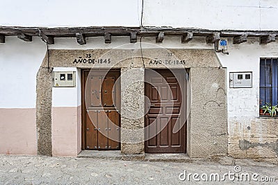 Two doors of neighboring houses built according to the inscription in the year 1845, example of the typical and traditional Editorial Stock Photo