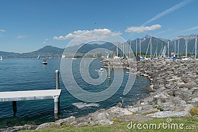 Villeneuve, VD / Switzerland - 31 May 2019: women prepare to leave Villeneuve harbor on Lake Geneva on a paddleboard excursion Editorial Stock Photo