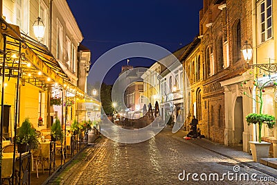 Vilnius Lithuania. Brightly Illuminated Pilies Street, Ancient Architecture, Deserted Outdoor Cafes Editorial Stock Photo