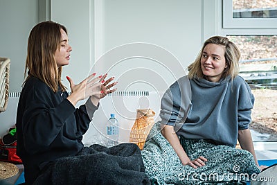 Couple of young caucasian beautiful girls enjoying time together during a yoga class or group activity Editorial Stock Photo
