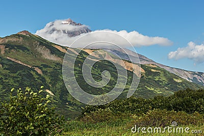 Vilyuchinsky stratovolcano in the clouds. View from brookvalley Spokoyny at the foot of outer north-eastern slope of Stock Photo