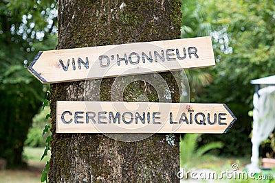 Vin d`honneur and ceremonie laique wooden arrow with text sign rustic wedding concept pointing for ceremony location means in Stock Photo