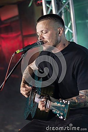 Zhenya Halych singer sing lyrical mood and play acoustic guitar on stage of Royal Pub, Faine Misto fest Editorial Stock Photo