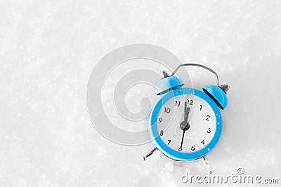Vintage alarm clock on the snow at sunset. The concept of Christmas and New Year. Stock Photo