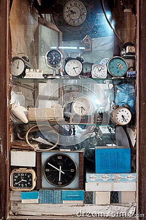 Vintage alarm clocks at the display window of a traditional clock repair shop Editorial Stock Photo