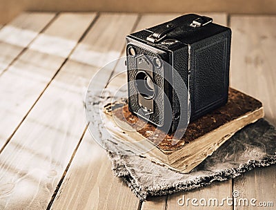 Vintage analogue film camera on a wooden table, old book, clothl. Retro photo. Copy space. Stock Photo