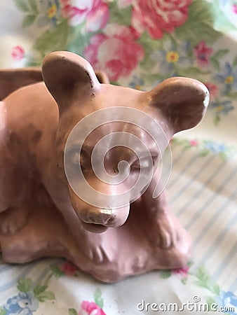 Vintage Antique Pink Satin Glaze Bear Cub Pottery Planter on Floral Silk Scarf Background Stock Photo