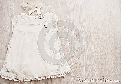 Vintage Baby White Lace Dress and Bow Headband on a Light Gray Wodden Background. Top View, Copy Space Stock Photo