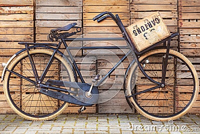 Vintage black cargo transport bicycle in front of old wooden crates Stock Photo