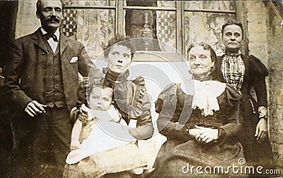 Vintage black and white photo of a Victorian family in front of house 1880s - 1900s. Editorial Stock Photo