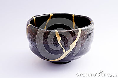 Vintage broken black tea ceremony bowl repaired with gold kintsugi technique Stock Photo