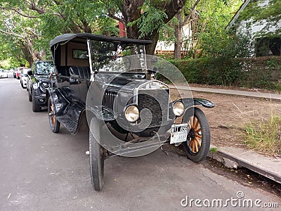 Vintage car black 1920s Ford Model T double phaeton parked in the street. Trees in the background. Editorial Stock Photo