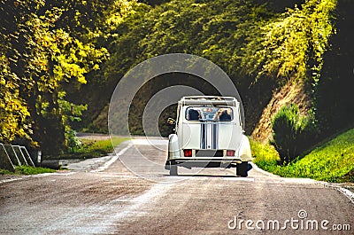 Vintage car country winding road back view friends road trip Stock Photo