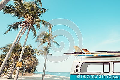 Vintage car parked on the tropical beach seaside with a surfboard on the roof Stock Photo