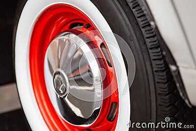 Vintage car wheel, painted red, the concept of the history of the development of cars. Close-up. Stock Photo