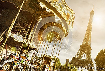 Vintage carousel close to Eiffel Tower, Paris with sun flare effect Stock Photo