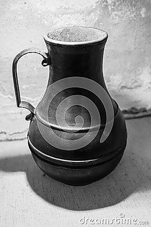 Antique metal jug, black and white photo. Stock Photo