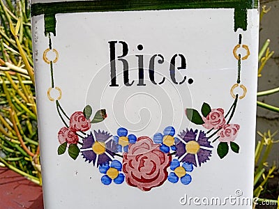 Vintage Ceramic Container with Rice written in Art Deco Style stencil font and a wreath of cornflowers and roses Stock Photo
