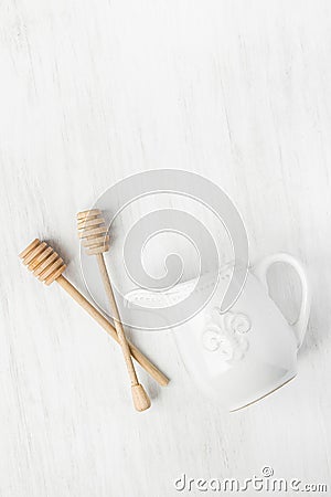 Vintage Ceramic Cream Milk Jug Wooden Honey Dippers Spoons on White Table. Holiday Baking Cooking Workshop Poster Stock Photo