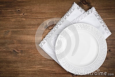 Vintage ceramic plate over table napkin on dark wooden background Stock Photo