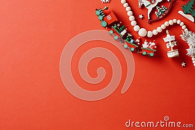 Vintage Christmas card template. Flat lay wooden locomotive, garland, horse, merry go round on red background Stock Photo