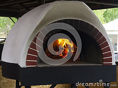 Vintage clay oven for cooking in a country house various dishes: flat cakes, pizzas, pies, cereals, meat, fish and potatoes. The Stock Photo