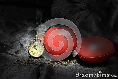 Vintage clock and red heart on black background ,Love and time concept in still life photography. Stock Photo