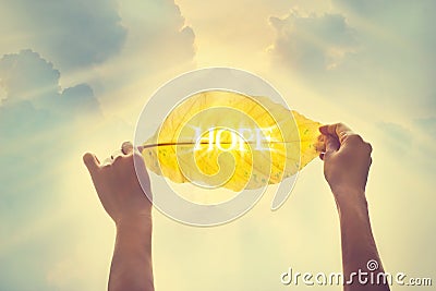 Vintage color tone, holding a yellow leaf in the sky of hope Stock Photo