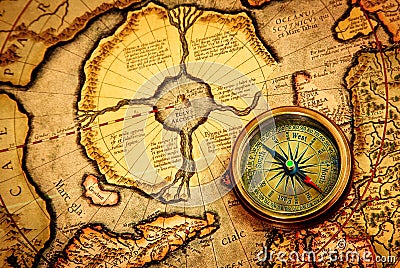 Vintage compass lies on an ancient map of the North Pole. Stock Photo