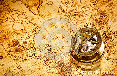 Vintage compass lies on an ancient world map. Stock Photo