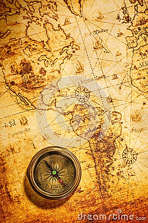 Vintage compass lies on an ancient world map. Stock Photo