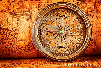 Vintage compass lies on an ancient world map. Stock Photo