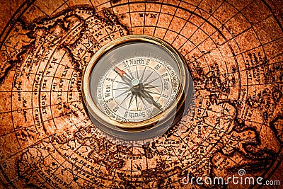 Vintage compass lies on an ancient world map. Stock Photo