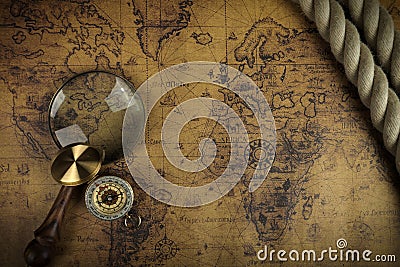 Vintage Compass and magnifying glass lies on an ancient world map - adventure stories background Stock Photo